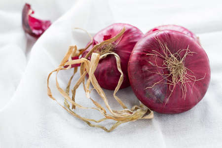 Close-up of red onions on a white tablecloth