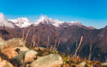 Spectacular view on Caucasus mountains with peaks covered with snow on bright sunny day. Krasnaya Polyana, Sochi, Russiaの写真素材