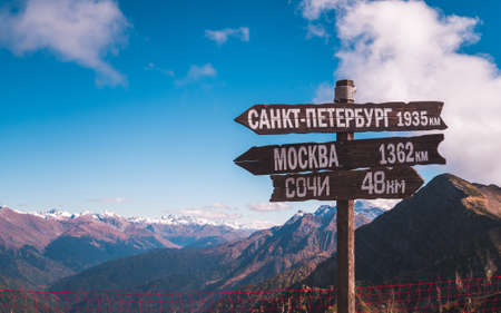 Wooden sign showing distance to St Petersburg, Moscow and Sochi on Rosa Peak at height of 2320 m in Krasnaya Polyana, Russiaの写真素材