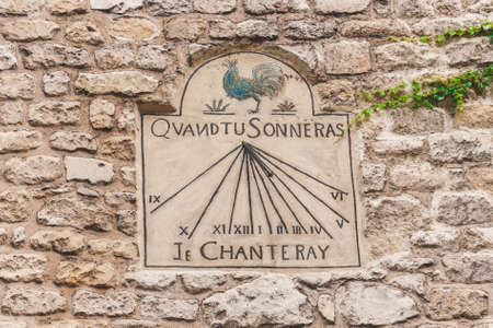 Very old sun dial on stone wall decorated with blue cock on Montmartre in Paris, Franceのeditorial素材