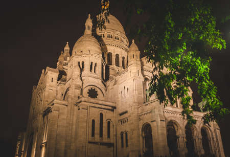 Illuminated Basilica of Sacred Heart (SacrÃ©-Coeur) of Paris at night. Popular landmark located on top of hill of Montmartreの写真素材