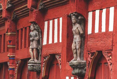 Historic red half-timbered house with wooden statues on facade in old town in Rennes, Brittany, Franceのeditorial素材