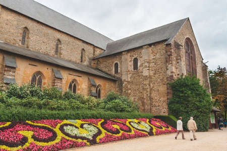 Unidentified people walk to entrance of Church of Notre-Dame-en-Saint-Melaine, remains of former Benedictine abbey in Rennes, Brittany, France.のeditorial素材