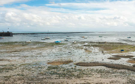 Boats and yachts lying on sea floor at low tide in Cancale, Brittany, Franceの写真素材