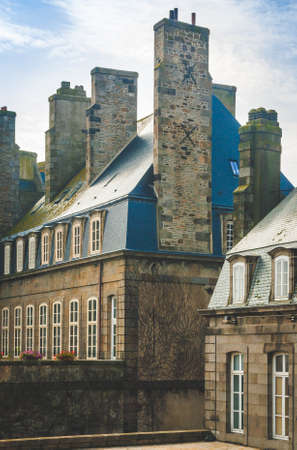 Old traditional house with blue roof, attic and chimneys in Saint-Malo, Brittany, Franceの写真素材