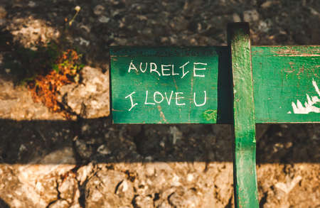 Fragment of green bench in park with handwritten words of love. Concept of love, romance, Valentine's dayの写真素材