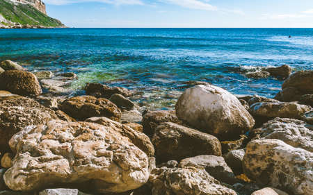 Huge rocks lying on the shore of Mediterranean sea on bright sunny day in Cassis, Franceの写真素材