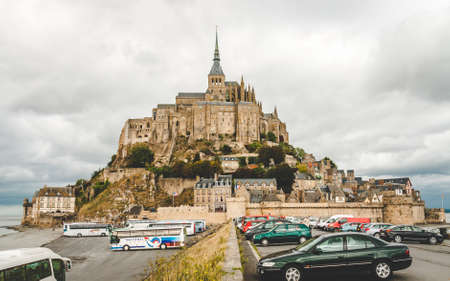 MONT SAINT-MICHEL, FRANCE - OCTOBER 5, 2009: Cars and tourist buses parked at foot of Le Mont...