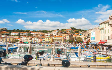 CASSIS, FRANCE - OCTOBER 10, 2009: Colorful houses and boats in port of Cassis. Tourists can take boat trips to see famous cliffs les Calanquesのeditorial素材