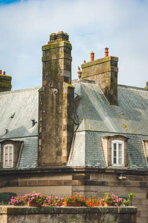 Fragment of old house roofed with slates with attic and decorated chimney in Saint-Malo, Brittany, Franceの写真素材
