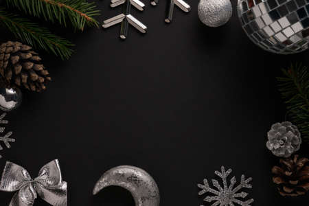 Christmas decorations of pine cone, spruce twigs, silver snowflakes, baubles, bow and moon against...