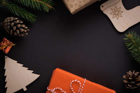 Christmas decorations, pine cones, spruce twigs, gifts on black background with copy space. Flat lay styleの写真素材
