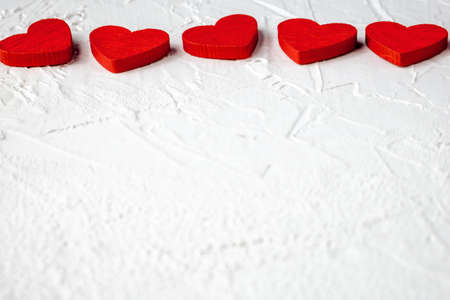 Red wooden hearts in horizontal line on white textured background with copy space. Symbol of love and Valentine's dayの写真素材