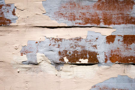 Close up of old worn cracked wall with peeling paint and plaster. Abstract texture background