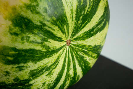 Close up shot of big round green striped watermelon on tableの写真素材