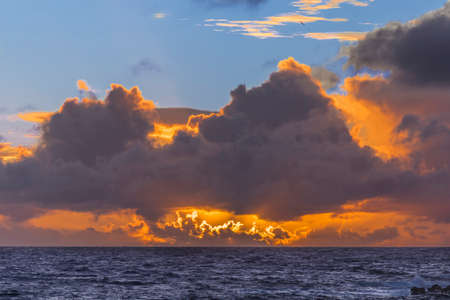 The clouds above the sky creating an amazing view of lines and formations with different lights and colorsの写真素材