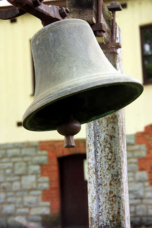 a Picture of a very old bell hanging on a dairy farm
