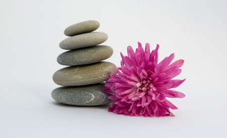 Pyramid from stones with a flower on a white backgroundの写真素材