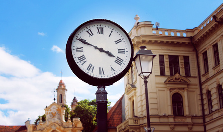 old town clock on the background of old buildings