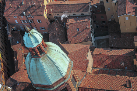 Beautiful dome of an old church on a background of red roofs in Bologna, Italy.