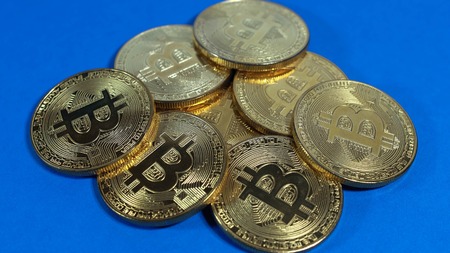 Several coins of gold bitcoins on a dark background.の写真素材