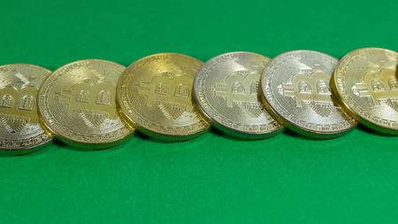 several coins of gold bitcoins on a dark background.