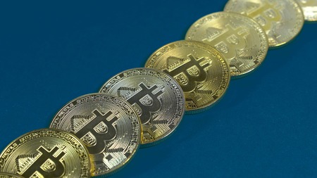 several coins of gold bitcoins on a dark background.の写真素材