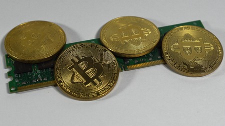 several coins of bitcoins and a strip of electronic memory on a light background.の写真素材