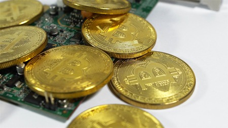 several coins of bitcoins and a strip of electronic memory on a light background.の写真素材