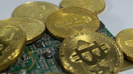 Several coins of bitcoins and a strip of electronic memory on a light background.の写真素材