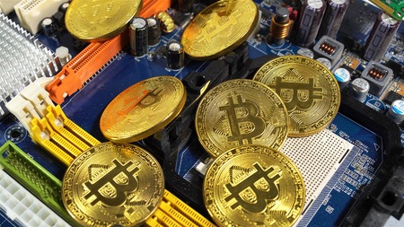several coins of bitcoins and a strip of electronic memory on a light background.の写真素材