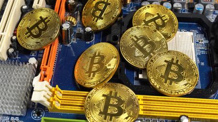 several coins of bitcoins and a strip of electronic memory on a light background.の写真素材