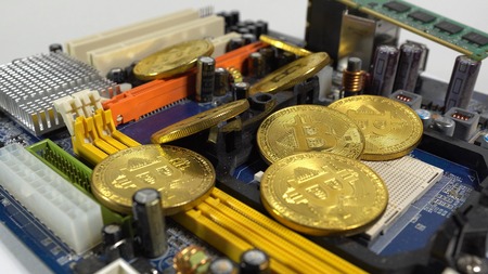 several coins of bitcoins and a strip of electronic memory on a light background.の写真素材