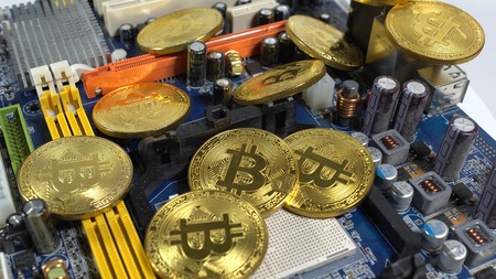 Several coins of bitcoins and a strip of electronic memory on a light background.の写真素材