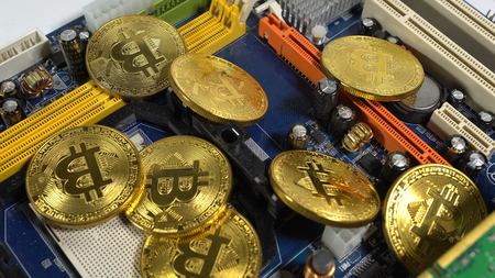 several coins of bitcoins and a strip of electronic memory on a light background.の写真素材