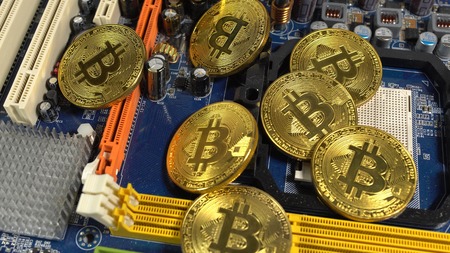 several coins of bitcoins and a strip of electronic memory on a light background.の写真素材