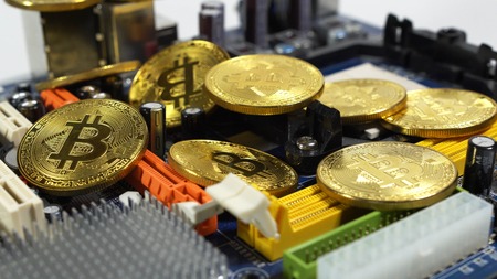 several coins of bitcoins and a strip of electronic memory on a light background.の写真素材