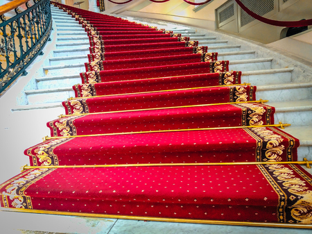 Beautiful curved staircase with red carpet for guestsの写真素材