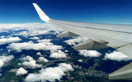 Mountains and white snow on the tops under the wing of the aircraft during the flight.の写真素材