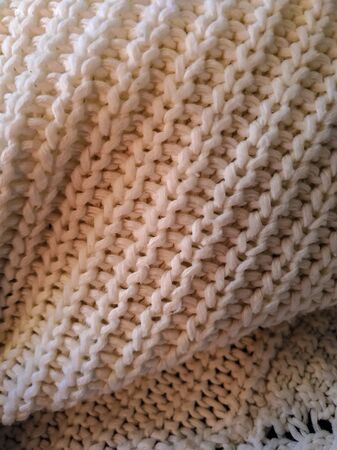 Knitted pattern from white wool. knitted fabric, handmade.の写真素材