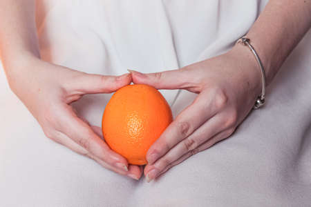 Ripe bright orange in tender female handsの写真素材