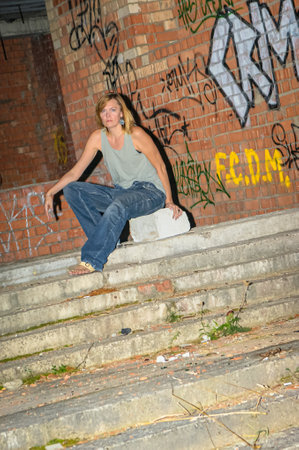 Young woman in rough clothes posing in an abandoned house.の写真素材