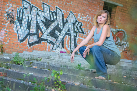 Young woman in rough clothes posing in an abandoned house.の写真素材
