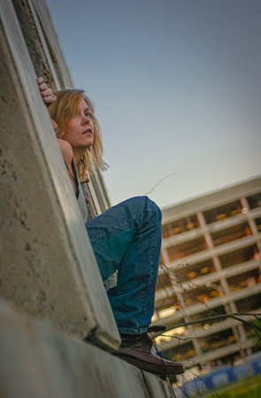Young woman in rough clothes posing in an abandoned house.の写真素材