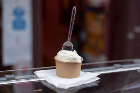 artisanal ice cream in eco natural paper cup with transparent spoon on topの写真素材