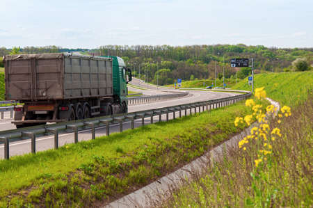 Expressway with multi-lane traffic, road bends with up and down slopes. Lorry close-up driving along...