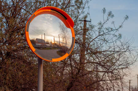 Round survey mirror on a pole to improve the visibility of the road, a dangerous intersection....