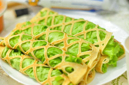 Openwork pancakes with lettuce and stuffing rolled into tubes, soft focus. Delicious picnic recipeの写真素材