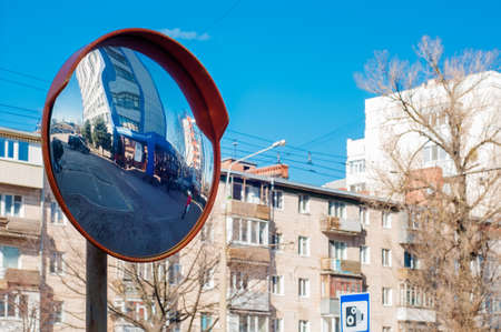 Round survey mirror on a pole to improve visibility of the road, dangerous intersection. Spherical...