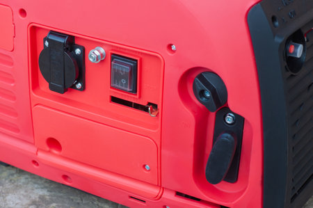 The red body of the electric gasoline generator from honda. Compact mobile voltage generator.